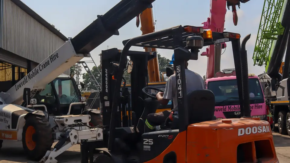 Picture of a forklift and bobcat parked next to each other