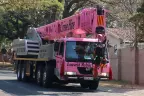 The Pink Lady crane driving along a suburban road